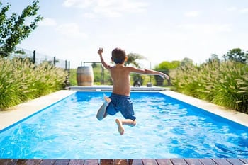 Boy jumping in pool