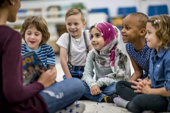 group of sitting children being read a story