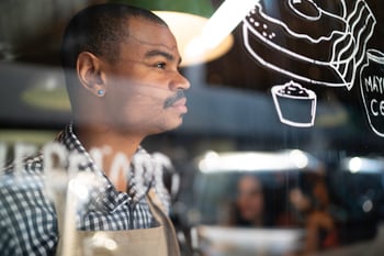 store owner looking out window