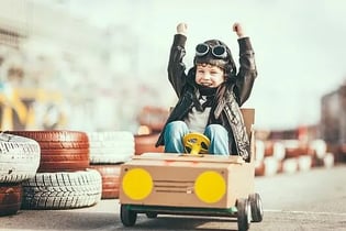 kid cheering in DIY race car