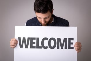 guy holidng welcome sign