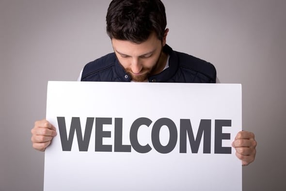 guy holidng welcome sign