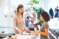 woman in store selling another woman