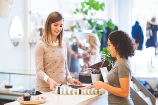 woman in store selling another woman