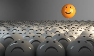 Yellow Smiley face balloon hovers above the crowd of white balloons