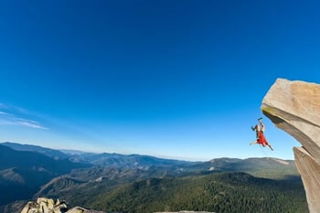Man hanging off the edge of a cliff