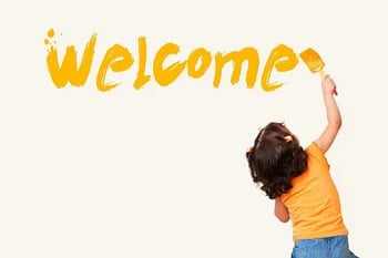 child painting the word welcome