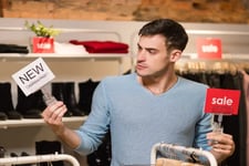 man with sale sign in store