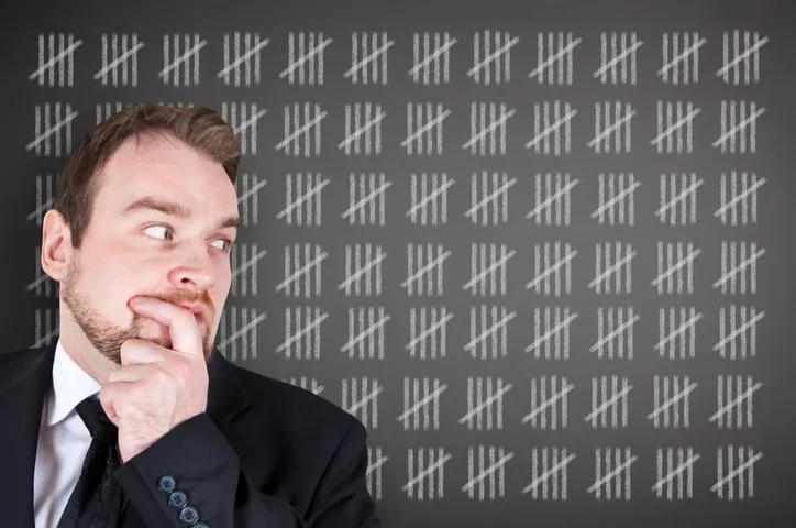 man looking sideways at tally marks