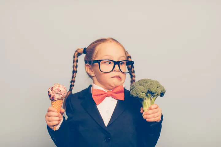 girl choosing between broccoli and an ice cream cone